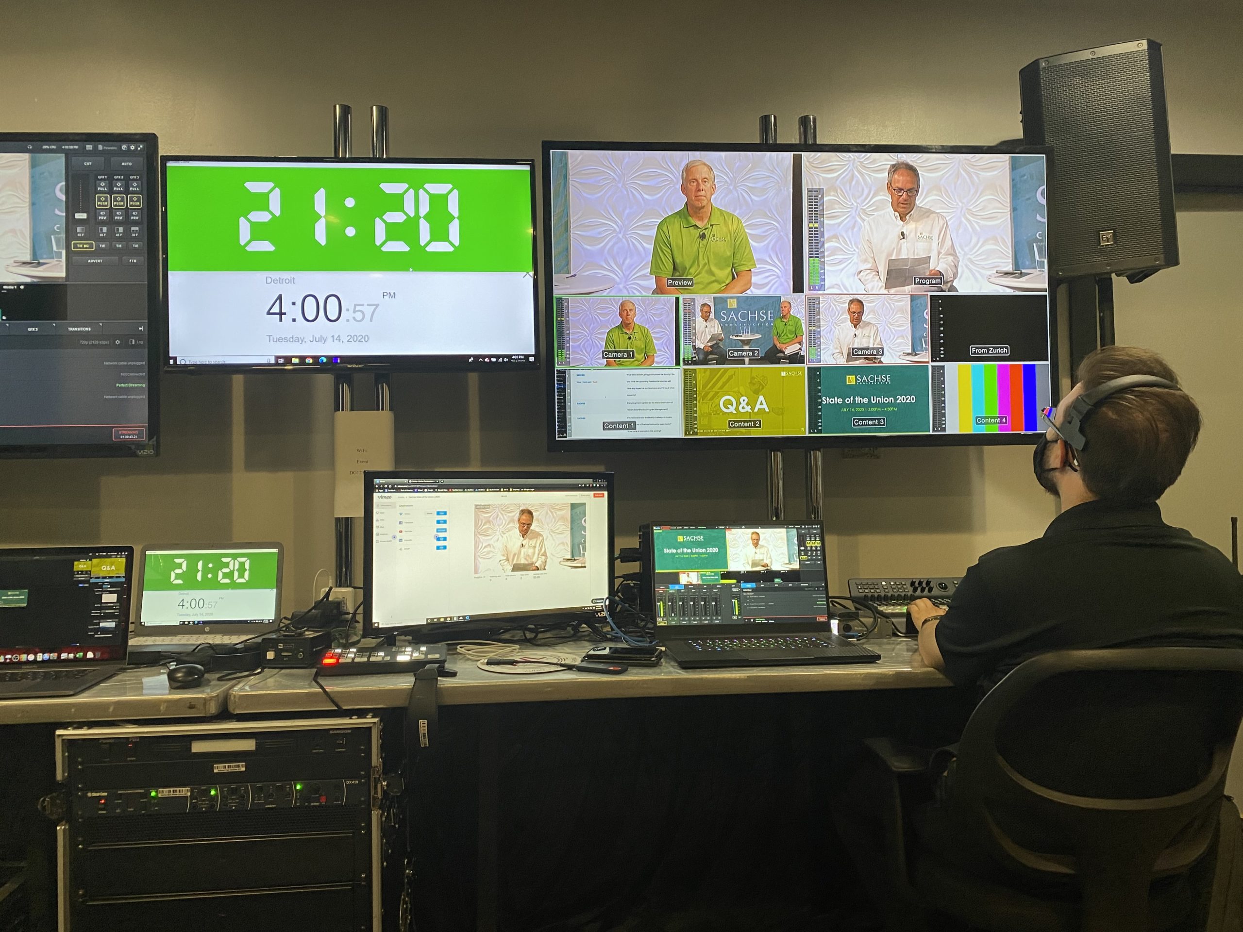 Virtual event control room with monitors, laptops, and engineer at the switching board