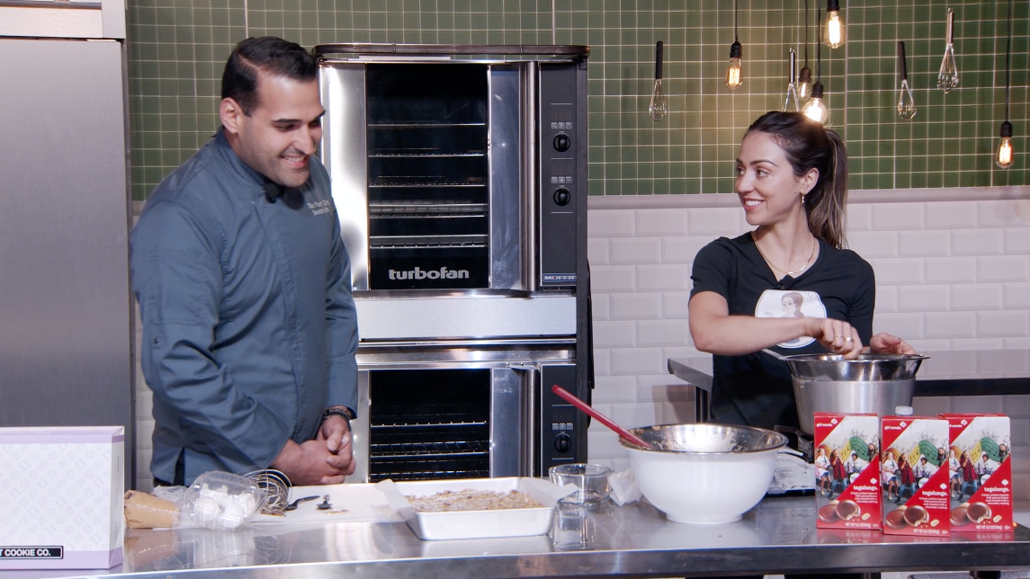 Two chefs talking in kitchen during cooking event livestream